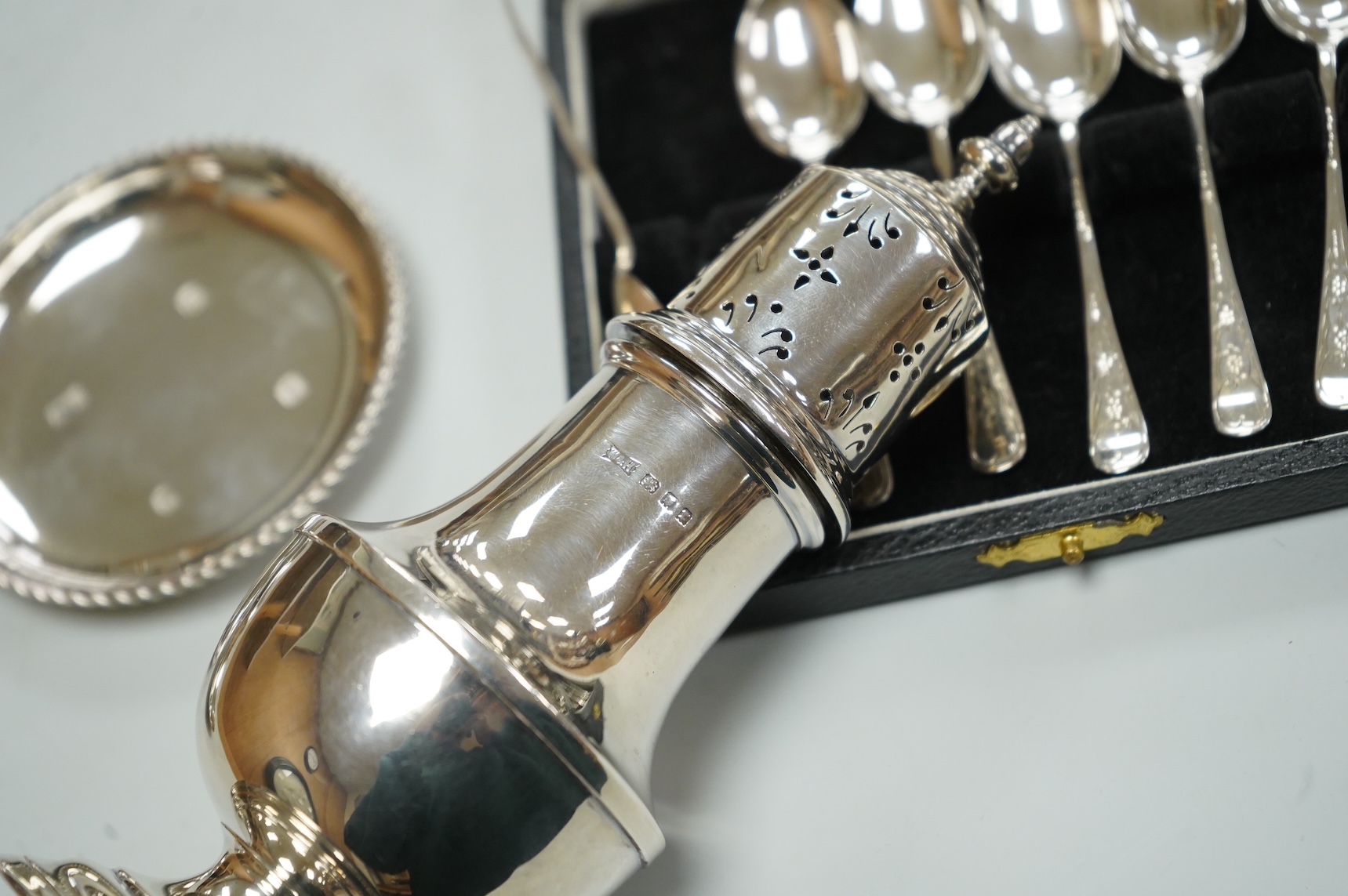 A George V silver sugar caster by Walker & Hall London 1932, 16cm, together with three silver nut dishes and a cased set of six silver coffee spoons.